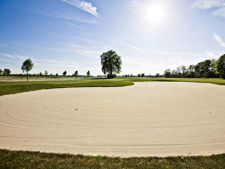 Eine makellose Golflandschaft in Bad Füssing umrahmt von Bäumen und Sonnenlicht.