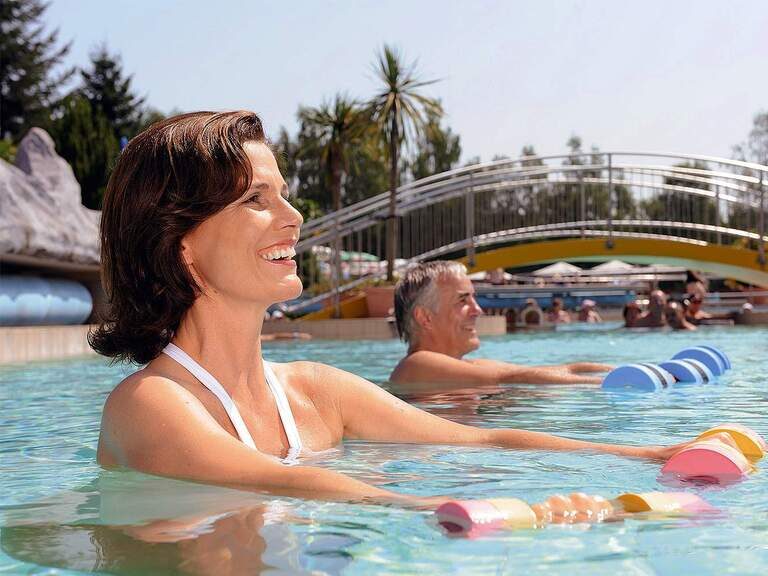 Eine Gruppe von Menschen während der Durchführung von Wassergymnastikübungen im Pool der Johannesbad Therme Bad Füssing.