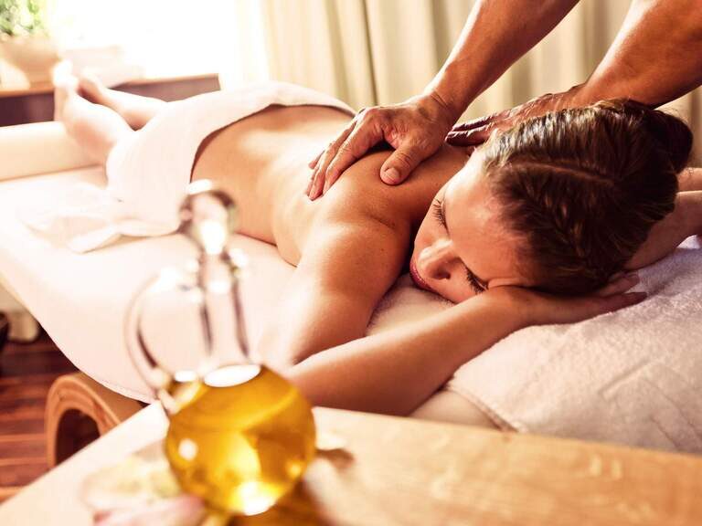 Eine Frau genießt eine entspannende Massage in einem Hotel von Bad Füssing.